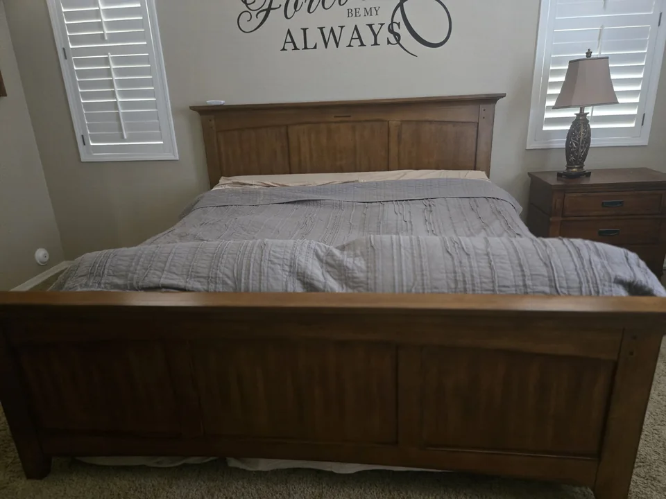 Wooden bed and bedside furniture in the estate home before the work