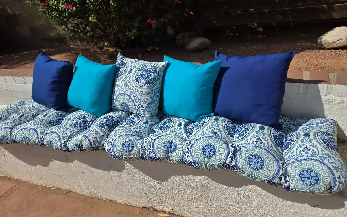 Replacement outdoor pillows in blue and white laid
out along the bench after delivery