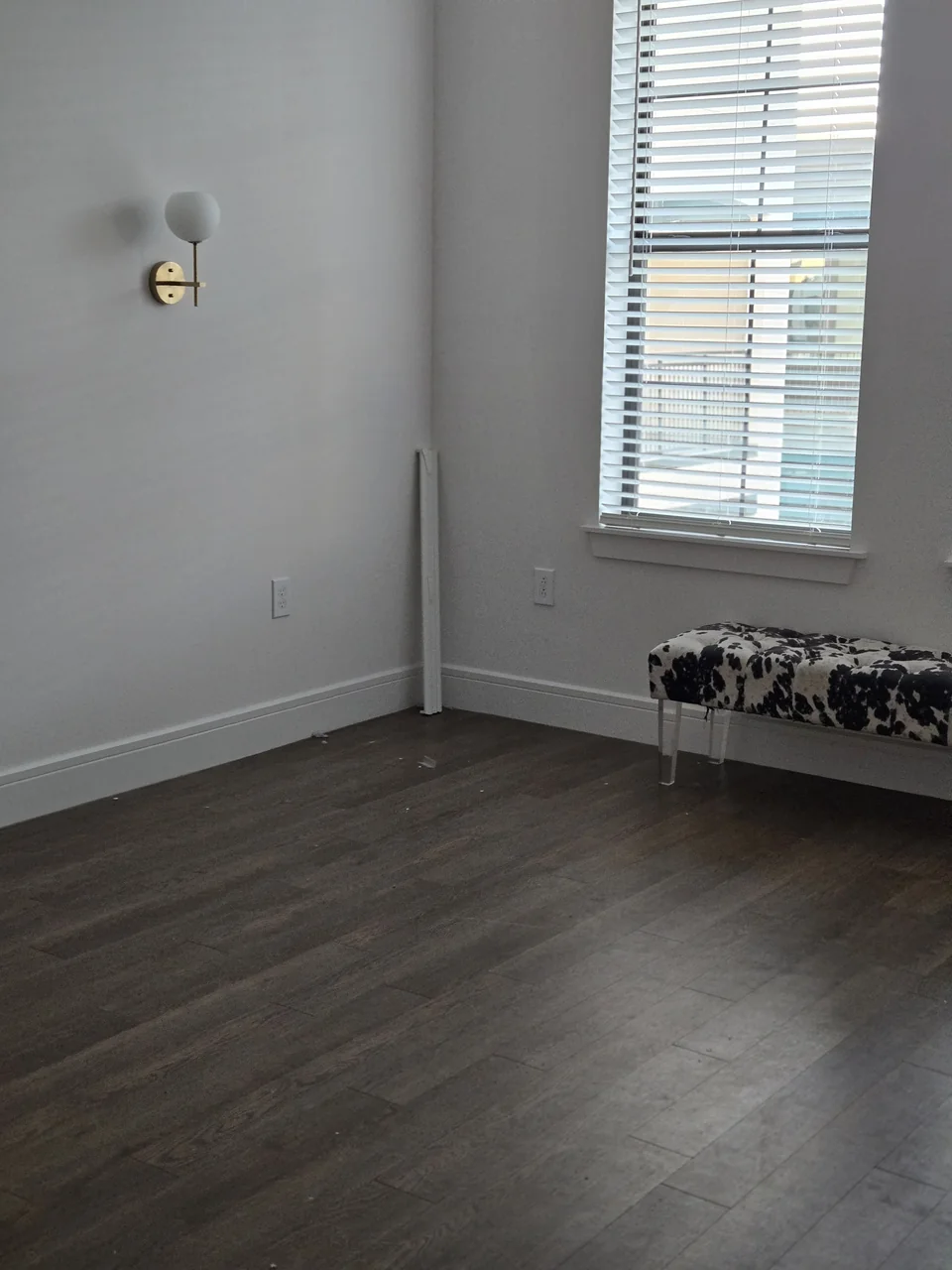 The same Scottsdale bedroom after the bed was removed, with a bench still beneath the window